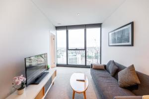 a living room with a couch and a flat screen tv at CBD Riverview 2B1B Apt w Shared Pool, Gym in Brisbane