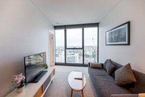 a living room with a couch and a flat screen tv at CBD Riverview 2B1B Apt w Shared Pool, Gym in Brisbane