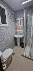 a bathroom with a toilet and a sink and a shower at BELLA Residence in San Vicente del Raspeig