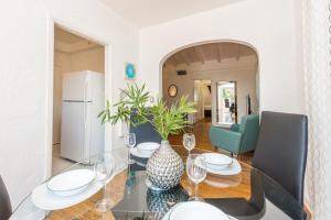 a dining room with a glass table with a vase at L'Etoile Apartments Part of the Oasis Casita Collection in Miami Beach