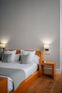 una camera con un grande letto con testiera in legno di Hotel Boutique Palacio Corredera a Jerez de la Frontera