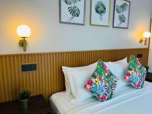 a bed in a hotel room with two pillows on it at Tropical Private Pool Villa 500m to the beach in Pantai Cenang