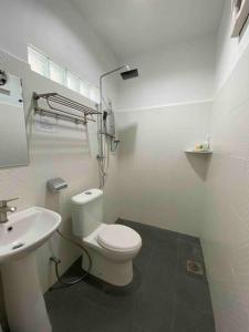 a bathroom with a white toilet and a sink at Tropical Private Pool Villa 500m to the beach in Pantai Cenang