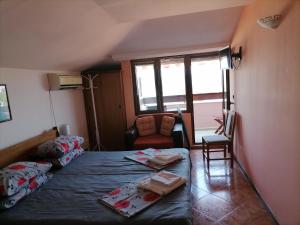 a bedroom with a bed and a chair and a window at Guesthouse Olimp in Sozopol