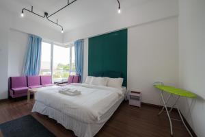 サンダカンにあるTrival Broadway Hut Homestay Sri Indah, Sandakanのベッドルーム(大型ベッド1台、紫色の椅子付) +24枚の写真