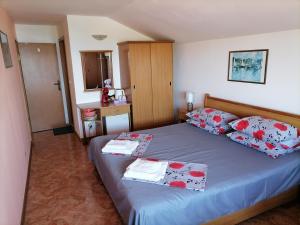 a bedroom with a blue bed with red and white pillows at Guesthouse Olimp in Sozopol
