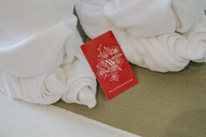 a red passport next to some white towels at Mittapan Hotel in Kanchanaburi