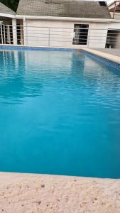 a blue swimming pool in front of a house at Beachscape At Black River Zermatt in Black River