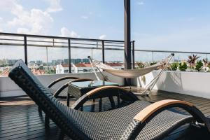 Un balcón con sillas y una hamaca en el techo. en Santa Grand Hotel East Coast a NuVe Group Collection en Singapur