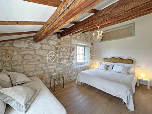 a bedroom with two beds and a stone wall at 202 - Villa Fernanda Trilocale elegante bellissimo, con 2 bagni, in Centro a pochi passi dal mare - SPIAGGIA e NAVETTA WHITE BEACH CLUB OMAGGIO dal lun al ven dal 24-08 in Sirolo