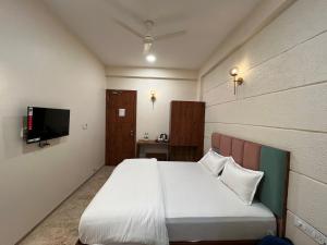Kasa Comfort Inn في إندوري: غرفة نوم بسرير وتلفزيون بشاشة مسطحة