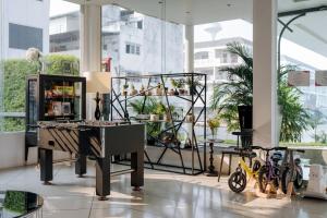 a store with a piano in a room with bikes at Mittapan Hotel in Kanchanaburi