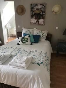 Un dormitorio con una cama blanca con toallas. en Aux portes de Pornichet, Chambres d'hôtes Ty'Sacha en Saint-Nazaire