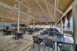 um restaurante com mesas e cadeiras e um tecto grande em Ladonia Hotels Mio Bianco em Akiarlar