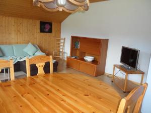 een woonkamer met een houten tafel en een televisie bij Wenk Elisabeth in Wildhaus