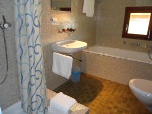 łazienka z umywalką, toaletą i wanną w obiekcie Wenk Elisabeth w mieście Wildhaus