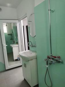 ein Bad mit einem Waschbecken und einem Spiegel in der Unterkunft Дива in Kardschali