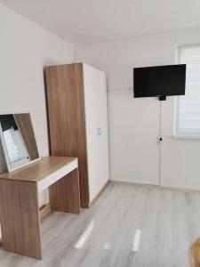 Zimmer mit einem Schreibtisch und einem TV. in der Unterkunft Дива in Kardschali