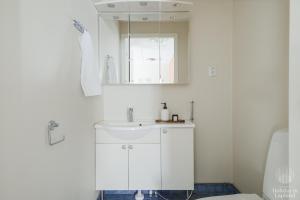 Baño blanco con lavabo y espejo en Holiday in Lapland - Alppilevi 1 B1, en Kittilä