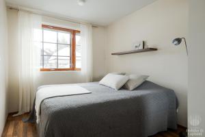 un lit dans une chambre blanche avec une fenêtre dans l'établissement Holiday in Lapland - Alppilevi 1 B1, à Kittilä