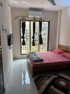 a bedroom with a bed and a large window at La Residence in Navi Mumbai