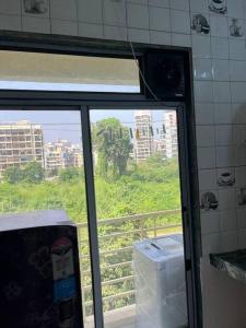 - une fenêtre dans la cuisine avec vue sur la ville dans l'établissement La Residence, à Navi Mumbai