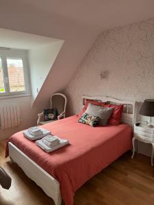 um quarto com uma cama grande e lençóis vermelhos em Aux portes de Pornichet, Chambres d'hôtes Ty'Sacha em Saint-Nazaire