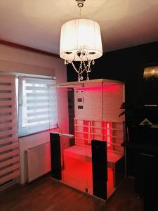 a room with a red lighted cabinet with a chandelier at 7.Nebo/ Spa apartman Vinkovci in Vinkovci