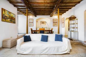sala de estar con sofá blanco y almohadas azules en The Balcony Suite - affaccio su Piazza del Campo, en Siena