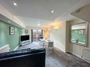 a living room with a black couch and a table at Suitely Museum Residence with roof terrace in Ipswich