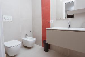 uma casa de banho branca com um WC e um lavatório em Sunseverino Rooms em Montecorice