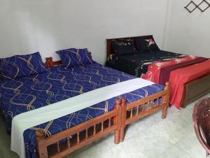 a bedroom with two beds and a couch at Nallur mylooran Arangam in Chiviyateru West