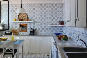 una cocina con armarios blancos y azulejos azules y blancos en Antique villa with enclosed garden and sea view, en Positano