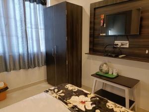 a room with a tv and a bed and a table at Arnnapurna Hotel & Resort in Jājpur