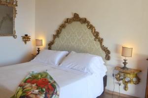 1 dormitorio con 1 cama blanca y 2 lámparas en Antique villa with enclosed garden and sea view, en Positano