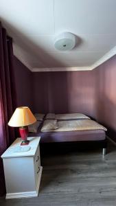 1 dormitorio con 1 cama y 1 mesa con lámpara en Artic Dream, en Gratangen