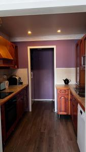 a kitchen with purple walls and wooden floors and a door at Artic Dream in Gratangen