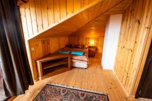 pokój z łóżkiem w drewnianym domku w obiekcie Apriltsi Hills w mieście Apriłci