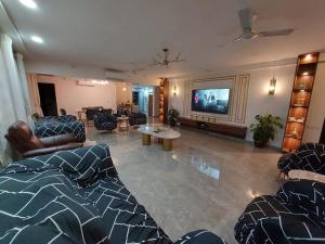 uma sala de estar com sofás e uma televisão de ecrã plano em Royal Nest Premium em Pune