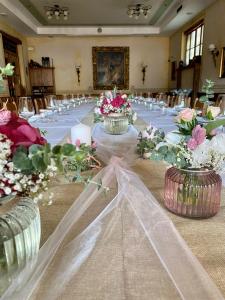 un lungo tavolo per banchetti con fiori in vaso di Landgasthof Faymann 