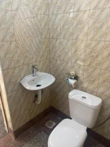 een badkamer met een wit toilet en een wastafel bij Kabale town flat in Kabale