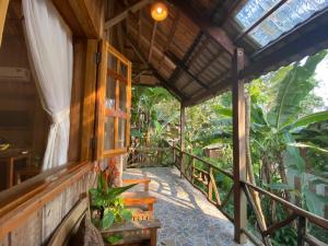 une terrasse couverte en bois d'une maison avec une fenêtre dans l'établissement Ancarine Beach Resort, à Duong Dong