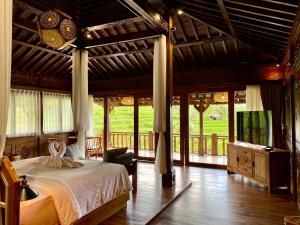 a bedroom with a bed and a television in it at Abian Ayu Villa in Sidemen