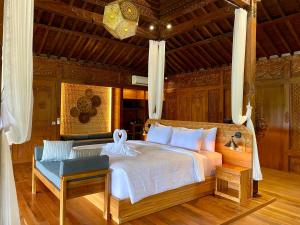 a bedroom with a bed and a chair in a room at Abian Ayu Villa in Sidemen