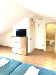 sala de estar con 2 camas y TV en Somo Surfskate hostel, en Castanedo