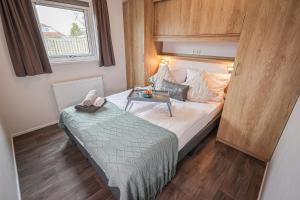 a small bedroom with a bed and a table at Ferienhaus Ostseechalet Seestern Gelting in Gelting