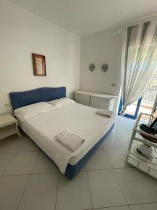 a white bedroom with a bed and a window at Residenza Santa Maria in Capri