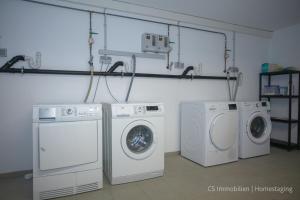 lavadero con 3 lavadoras y lavadora y secadora en Lago Azzurrro, en Langenargen