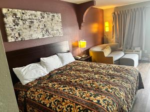 una habitación de hotel con una cama y una silla en Southern Inn, en Manchester