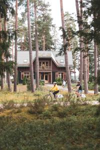 un grupo de personas montando bicicletas delante de una casa en LVM tūrisma un atpūtas centrs "Spāre", en Spāre